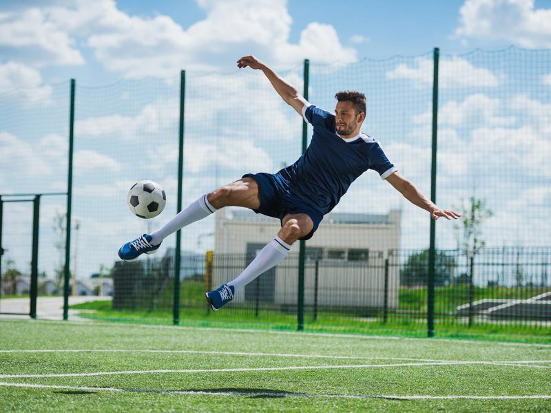 athletic-soccer-player-kicking-ball-on-soccer-pitc-2021-08-29-12-17-06-utc